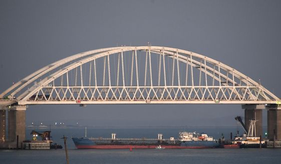 FILE - In this file photo taken on Sunday, Nov. 25, 2018, a Russian tanker under the the Kerch bridge blocks the passage to the Kerch Strait near Kerch, Crimea. The Ukrainian Security Service (SBU) said in a statement Thursday July 25, 2019, that it has seized the Russian tanker moored in a Ukrainian Black Sea port. (AP Photo)