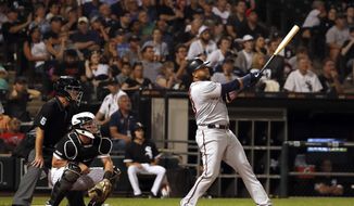 Minnesota Twins&#39; Nelson Cruz watches his two run home run during the fifth inning of a baseball game as Chicago White Sox catcher James McCann (33) and home plate umpire Ed Hickox (15) look on Thursday, July 25, 2019, in Chicago. It was Cruz&#39;s third home run of the game. (AP Photo/Jeff Haynes)