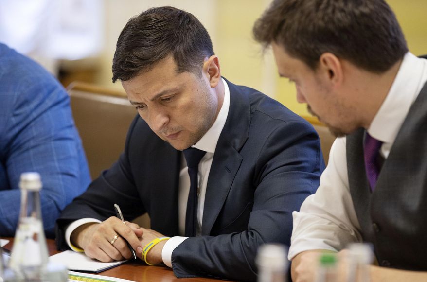 Ukrainian President Volodymyr Zelenskiy, left, attends a Cabinet meeting in Kiev, Ukraine, Friday, July 19, 2019. (Ukrainian Presidential Press Office via AP)