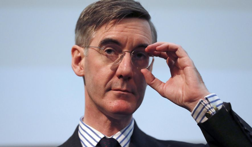 FILE - In this Wednesday, Jan. 23, 2019 file photo, British lawmaker Jacob Rees-Mogg gestures as he speaks at a meeting for eurosceptic think tank The Bruges group, in London. The new leader of Britain’s House of Commons has some old-fashioned rules for staff, banning metric measurements and ordering men to be addressed as “esquire.” A memo for staff of Conservative lawmaker Jacob Rees-Mogg published Friday, July 26 says men without aristocratic titles should get the suffix “Esq.” in correspondence. (AP Photo/Alastair Grant, file)