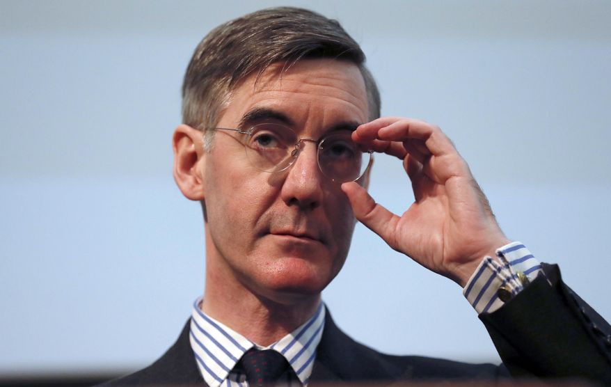 FILE - In this Wednesday, Jan. 23, 2019 file photo, British lawmaker Jacob Rees-Mogg gestures as he speaks at a meeting for eurosceptic think tank The Bruges group, in London. The new leader of Britain’s House of Commons has some old-fashioned rules for staff, banning metric measurements and ordering men to be addressed as “esquire.” A memo for staff of Conservative lawmaker Jacob Rees-Mogg published Friday, July 26 says men without aristocratic titles should get the suffix “Esq.” in correspondence. (AP Photo/Alastair Grant, file)