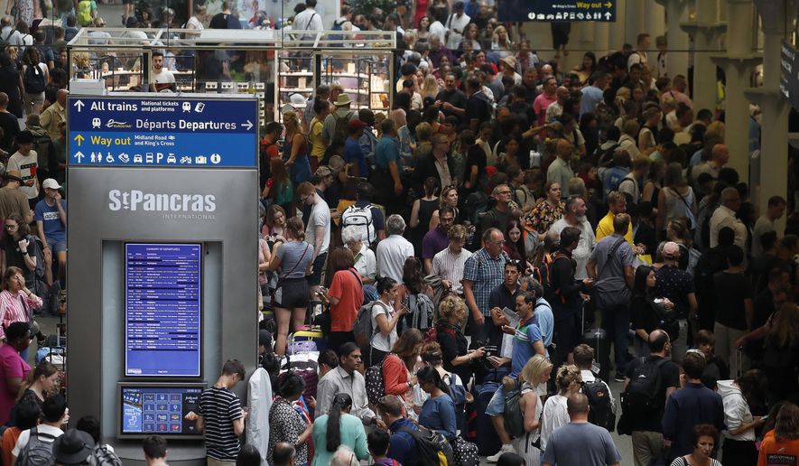 People wait at the St Pancras International train station to board the Eurostar in London, Friday, July 26, 2019. A power outage at one of France's busiest train stations is disrupting travel on the Eurostar to and from London and other routes around the region. (AP Photo/Frank Augstein)
