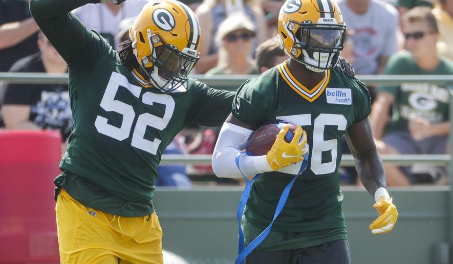 Green Bay Packers' Rashan Gary knocks the ball from Randy Ramsey during NFL football training camp Thursday, July 25, 2019, in Green Bay, Wis. (AP Photo/Morry Gash)