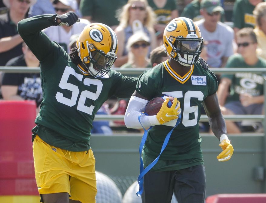 Green Bay Packers' Rashan Gary knocks the ball from Randy Ramsey during NFL football training camp Thursday, July 25, 2019, in Green Bay, Wis. (AP Photo/Morry Gash)