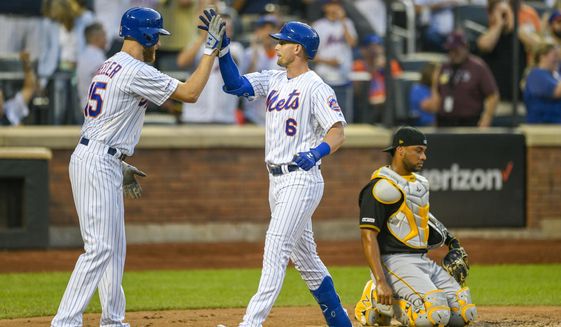 New York Mets Jeff McNeil, center celebrates a three run home run with New York Mets Zack Wheeler as Pittsburgh Pirates catcher Elias Diaz, right looks on during the third inning of a baseball game, Friday, July 26, 2019, in New York. New York Mets Amed Rosario also scored on the play. (AP Photo/Corey Sipkin)