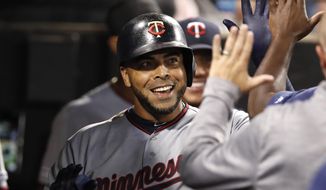Minnesota Twins&#39; Nelson Cruz celebrates with teammates in the dugout after hitting a solo home run during seventh inning of a baseball game against the Chicago White Sox, Friday, July 26, 2019, in Chicago. (AP Photo/Jeff Haynes)