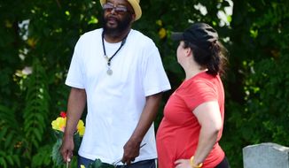 In this July 20, 2019, photo, Wayne Scott Sr. talks with a volunteer at Lebanon Cemetery in North York, Pa. A recently launched community effort has helped community members find graves of their loved ones who have been buried at the largest black cemetery in York County. As years went by, those graves and many others in the cemetery were covered by dirt and overgrown grass, making it difficult for many to locate the resting places of their loved ones. (Matt Allibone/York Daily Record via AP)