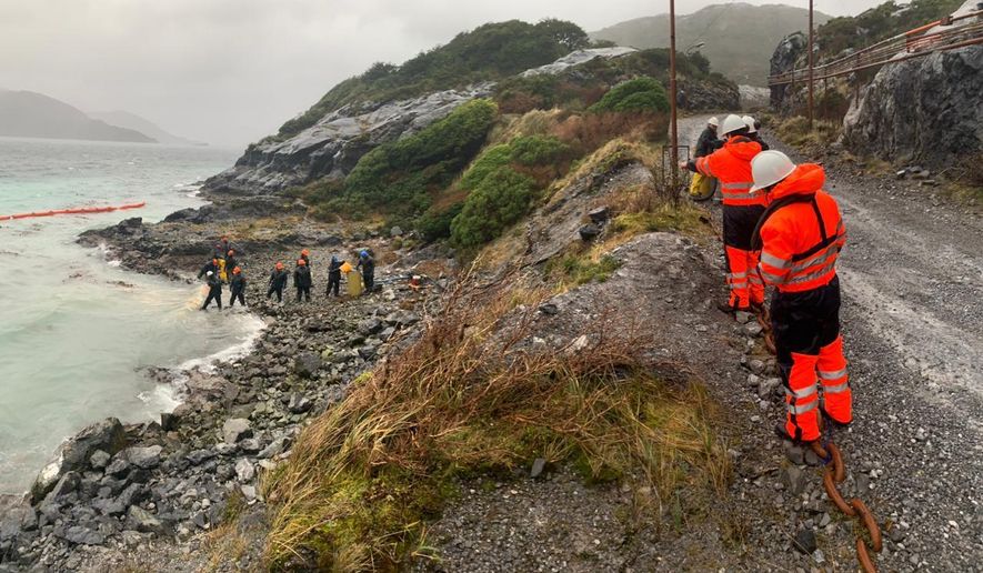 In this photo distributed by the Chile navy, sailors work to contain damage from an oil spill, on Guarello Island in Chile, Sunday, July 28, 2019. Chile's navy on Sunday confirmed the spillage of 40,000 liters of diesel oil into the sea in a remote and pristine area of the South American country's Patagonia and said it is working to mitigate the effects. (Chile navy via AP)