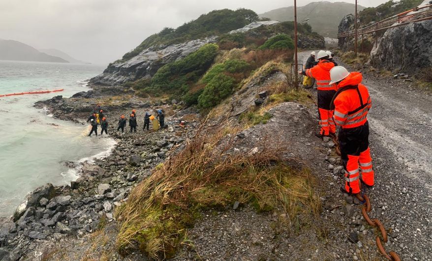 In this photo distributed by the Chile navy, sailors work to contain damage from an oil spill, on Guarello Island in Chile, Sunday, July 28, 2019. Chile's navy on Sunday confirmed the spillage of 40,000 liters of diesel oil into the sea in a remote and pristine area of the South American country's Patagonia and said it is working to mitigate the effects. (Chile navy via AP)