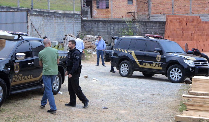 Police inspect the vehicles that were left by suspects involved in heist carried out at Sao Paulo's Guarulhos international airport, in the Jardim Pantanal neighborhood of Sao Paulo, Brazil, Thursday, July 25, 2019. Authorities at Sao Paulo's Guarulhos international airport say eight armed men raided a terminal and escaped with some 750 kilos (750,000 grams) of precious metals. The airport operator said that the thieves bypassed security systems by using two cars that looked like police vehicles. (Paulo Lopes/Futura Press via AP)