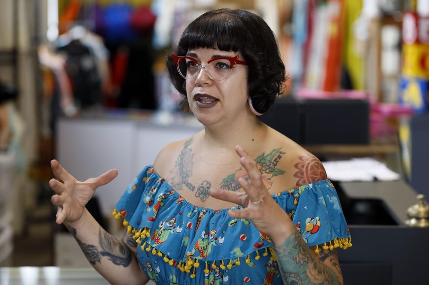 Becca Clark talks about her newly relocated vintage clothing and jewelry store, Tuesday, July 16, 2019, in Davenport, Iowa. Hundreds of communities line the Mississippi River, but Davenport is among the few where people can dip their toes into the water without scaling a flood wall or levee. (AP Photo/Charlie Neibergall)