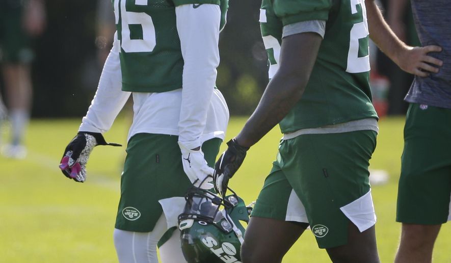 New York Jets' Le'Veon Bell, left, talks with Elijah McGuire during a practice at the NFL football team's training camp in Florham Park, N.J., Friday, July 26, 2019. (AP Photo/Seth Wenig)