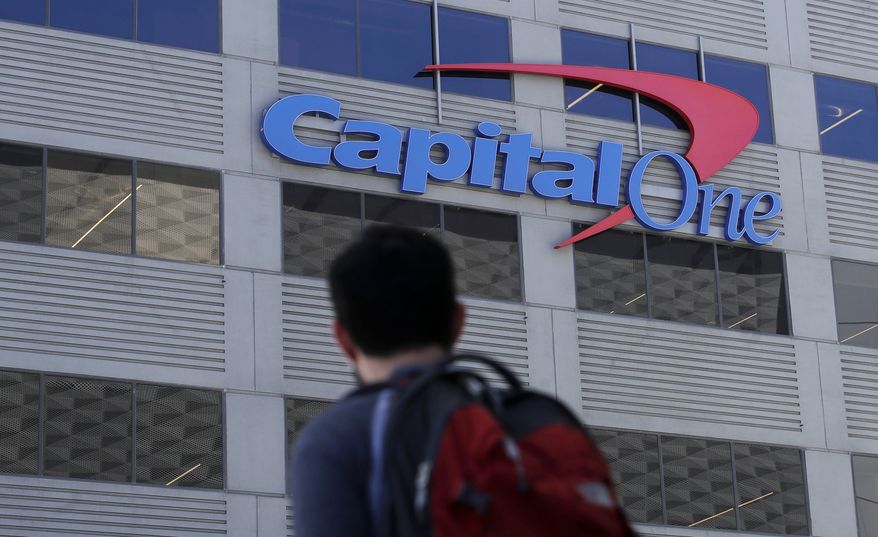 In this July 16, 2019, file photo, a man walks across the street from a Capital One location in San Francisco. Capital One says a hacker got access to the personal information of over 100 million individuals applying for credit. The McLean, Virginia-based bank said Monday, July 29, it found out about the vulnerability in its system July 19 and immediately sought help from law enforcement to catch the perpetrator. (AP Photo/Jeff Chiu)