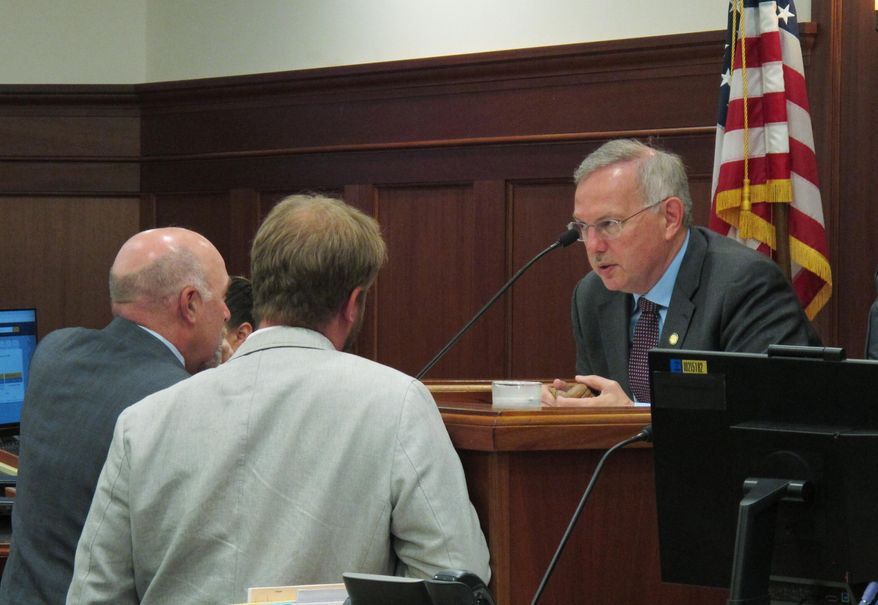 Alaska House Speaker Bryce Edgmon, right, speaks to Reps. Adam Wool, left, and Grier Hopkins before the start of the House floor session on Monday, July 29, 2019, in Juneau, Alaska. The House passed a funded capital budget on Monday. (AP Photo/Becky Bohrer)