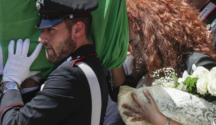 Carabinieri officer Mario Cerciello Rega&#39;s wife, Rosa Maria, right, follows the coffin containing the body of her husband during his funeral in his hometown of Somma Vesuviana, near Naples, southern Italy, Monday, July 29, 2019. Two American teenagers were jailed in Rome on Saturday as authorities investigate their alleged roles in the fatal stabbing of the Italian police officer on a street near their hotel. (AP Photo/Andrew Medichini)