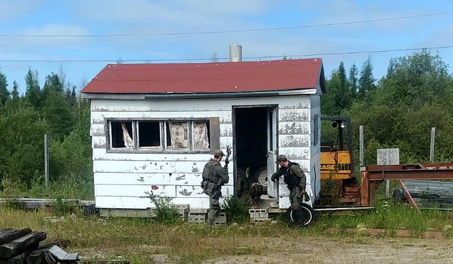 In this recent photo provided by the Royal Canadian Mounted Police, RCMP officers canvas homes and buildings in the Gillam, Manitoba area, as they continue to search for two teenagers being sought in the killings of three people in northern British Columbia. (Royal Canadian Mounted Police via AP)