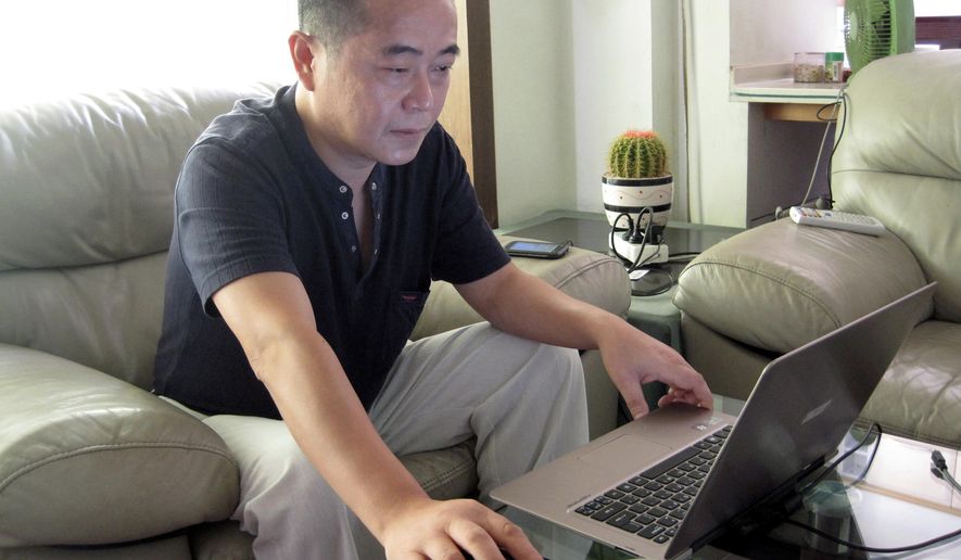 In this Sept. 18, 2012, file photo, veteran rights activist Huang Qi works on his laptop in his home in Chengdu in southwestern China's Sichuan province. Huang has been sentenced to 12 years in prison on the charge of leaking secrets to a foreign entity, more than two years after his arrest. Huang, who founded a website documenting official rights abuses, has been jailed twice before, including in 2008 after advocating for parents whose children were killed in a massive earthquake in the southwestern province of Sichuan. (AP Photo/Gillian Wong, File) **FILE**