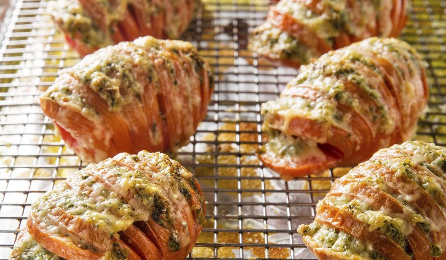 This undated photo provided by America's Test Kitchen in July 2019 shows Hasselback Tomatoes in Brookline, Mass. This recipe appears in the cookbook "New Essentials." (Joe Keller/America's Test Kitchen via AP)