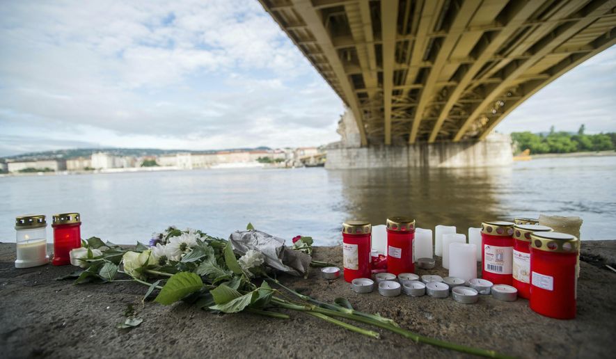 FILE - In this Friday, May 31, 2019 file photo, candles and flowers are left under the Margaret Bridge near the spot where a boat carrying South Korean tourists sank in Budapest, Hungary. The Ukrainian captain of a cruise ship involved in a crash on the Danube River that killed 28 people is back in police custody. Hungarian police said Monday, July 29, 2019 that the captain, who was out on bail after being detained for his suspected responsibility in the May 29 collision, is now also suspected of failing to provide assistance after the accident and was being interrogated. Only seven South Korean tourists survived the collision which capsized and sank their tour boat. (Zoltan Balogh/MTI via AP, File)