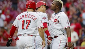 Cincinnati Reds&#39; Jose Iglesias, center, celebrates with Josh VanMeter (17) and Yasiel Puig, right, after hitting a grand slam off Pittsburgh Pirates relief pitcher Montana DuRapau in the second inning of a baseball game, Monday, July 29, 2019, in Cincinnati. (AP Photo/John Minchillo)