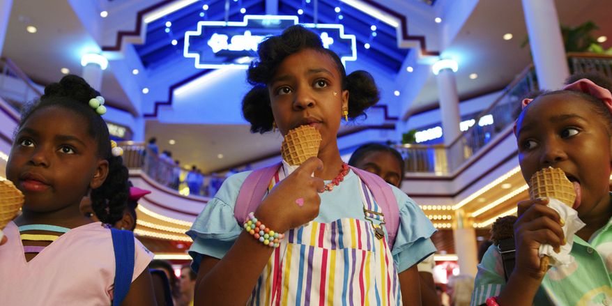 This image released by Netflix shows Priah Ferguson, center, in a scene from "Stranger Things." Ferguson, a 12-year-old Atlanta middle schooler, has given season 3 of the sci-fi, back-to-the-‘80s Netflix show a jolt of sassy electricity, playing Erica, a “My Little Pony”-obsessed, He-Man stealing, walkie-talkie intercepting little sister of Lucas, played by Caleb McLaughlin. (Netflix via AP)