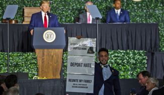 Virginia Del. Ibraheem Samirah, D-Fairfax, yells as he interrupts President Donald Trump&#39;s addresses Tuesday, July 30, 2019, in Jamestown, Va., during a commemorative meeting of the Virginia General Assembly at Jamestown Settlement on the 400th anniversary of the meeting of the original House of Burgess. (AP Photo/Steve Helber)