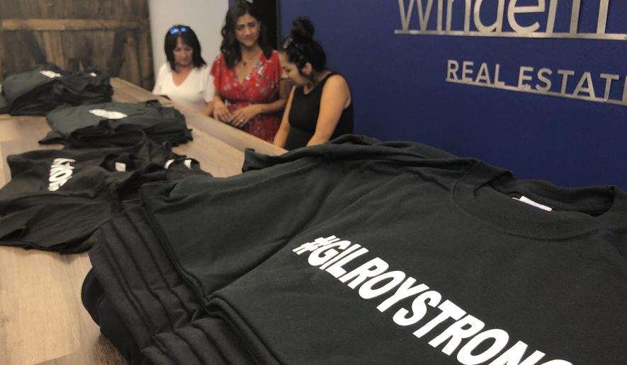 Employees and volunteers at Windermere Real Estate work at selling "#Gilroy Strong" T-shirts, with proceeds benefiting shooting victims, in Gilroy, Calif., Tuesday, July 30, 2019. Gilroy is the latest U.S. community to vow that a gunman wouldn't tear them down. A shooter killed two children and a 25-year-old from upstate New York at the Gilroy Garlic Festival this past weekend. People in the rural community known for growing garlic have raised their voices in the defiant cry of "Gilroy Strong" as authorities seek a motive for the killings. (AP Photo/Haven Daley)