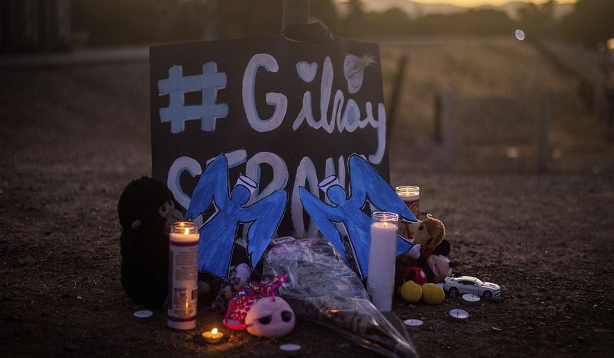 Candles burn at a makeshift memorial for Gilroy Garlic Festival shooting victims outside the festival grounds, Monday, July 29, 2019, in Gilroy, Calif. (AP Photo/Noah Berger)