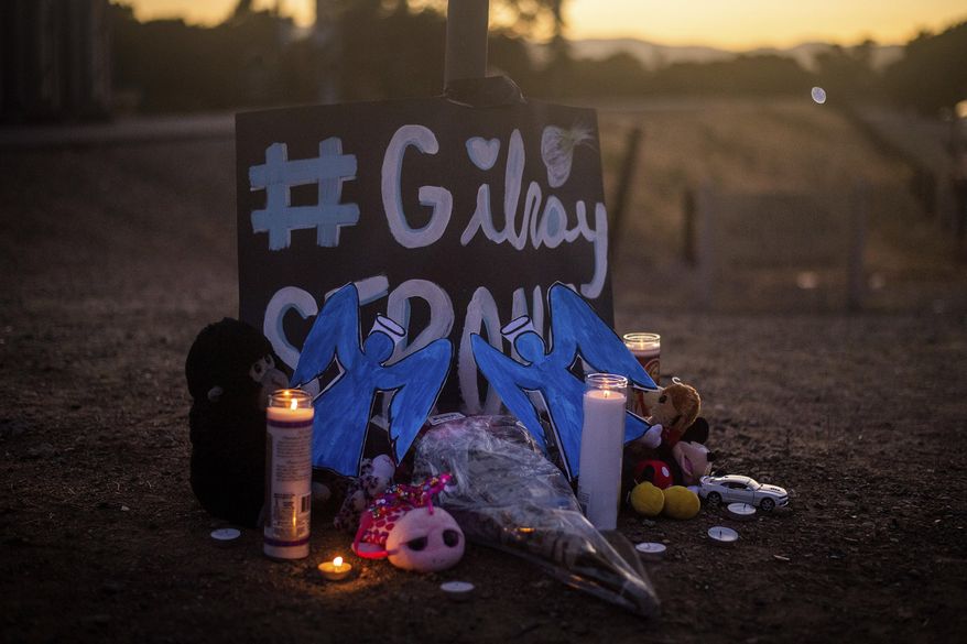 Candles burn at a makeshift memorial for Gilroy Garlic Festival shooting victims outside the festival grounds, Monday, July 29, 2019, in Gilroy, Calif. (AP Photo/Noah Berger)