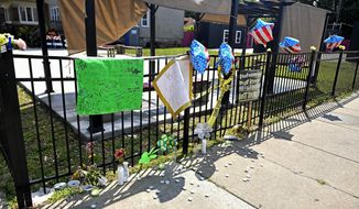 A memorial stands at 75th Street and Stewart Avenue in Chicago, where two women were slain in a drive-by shooting Friday night. (John Alexander/Chicago Sun-Times via AP)