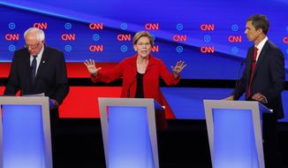 Sen. Elizabeth Warren, D-Mass., speaks as she participates in the first of two Democratic presidential primary debates hosted by CNN Tuesday, July 30, 2019, in the Fox Theatre in Detroit. Sen. Bernie Sanders, I-Vt., left, and former Texas Rep. Beto O&#39;Rourke listen. (AP Photo/Paul Sancya)