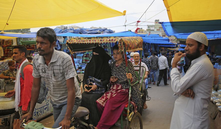 Indian Muslim women ride a cycle rickshaw in New Delhi, India, Tuesday, July 30, 2019. India's parliament has approved a bill to end the Muslim practice of instant divorce nearly two years after the Supreme court held that it violated the constitutional rights of Muslim women. (AP Photo/Altaf Qadri)