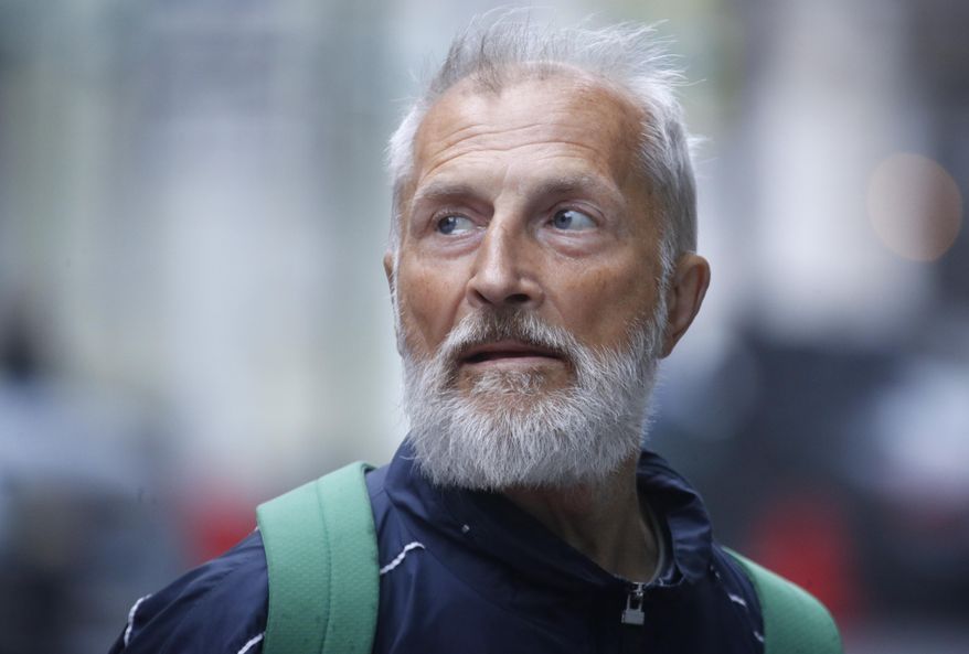 In this Saturday, May 25, 2019 photo Vyacheslav Rasner, 68, waiting for clients who want him to lead them around some parts of the city's Nevsky Prospekt main avenue in St.Petersburg, Russia, as he has become an unexpectedly popular tour guide after surviving a decade of homelessness. Rasner guides tourists around the ornate magnificence and the cruel poverty of the city, a good education for visitors who have already seen the city’s more-renowned sights, but his erudition and affection for the city shine through. (AP Photo/Dmitri Lovetsky)