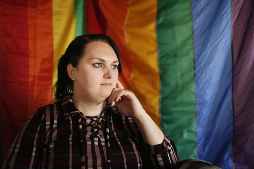 FILE - In this Feb. 6, 2018, file photo, Destiny Clark, 33, of Odenville, Ala., sits infant of a pride flag for a portrait in Odenville, Ala. Three transgender women including Clark have filed a lawsuit challenging Alabama's requirement for a person to show proof of sex-altering surgery in order to change the gender designation on their driver's license. (AP Photo/Brynn Anderson, File)