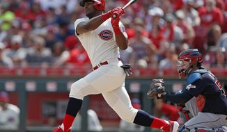 FILE - In this July 6, 2019, file photo, Cincinnati Reds&#39; Yasiel Puig, left, follows through on a two-run home run off Cleveland Indians starting pitcher Shane Bieber during the first inning of a baseball game, in Cincinnati. The Indians bulked up for the playoff race by trading temperamental starter Trevor Bauer before the deadline to Cincinnati in a three-team deal they hope can help them run down the Minnesota Twins. Cleveland, which trails the AL Central by three games but leads the wild-card race, sent Bauer to the Reds for slugger Yasiel Puig and left-hander Scott Moss. The Indians also acquired outfielder Franmil Reyes, lefty Logan Allen and infield prospect Victor Nova from the San Diego Padres, who acquired outfielder Taylor Trammel from the Reds.(AP Photo/Gary Landers, File)