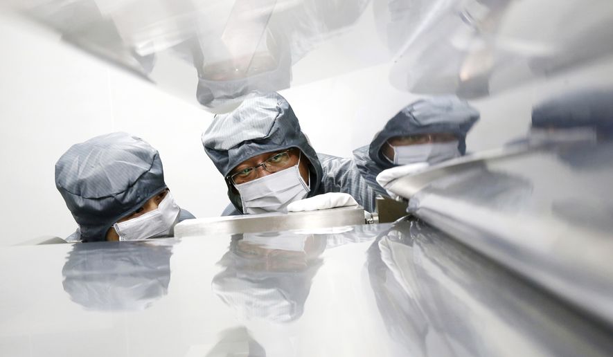 FILE - In this May 24, 2019,file photo, workers talk at a composite materials manufacturing plant in Nantong in eastern China's Jiangsu province. China’s factory activity contracted in July for a third month amid a tariff war with Washington and weak domestic demand. A monthly index released Wednesday, July 31, 2019, by an industry group, the China Federation of Logistics & Purchasing, stood at 49.7 on a 100-point scale. (Chinatopix via AP, File)
