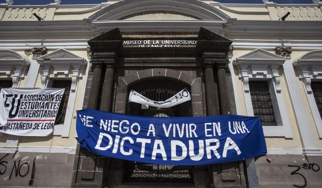 The Spanish message &amp;quot;I refuse to live in a dictatorship&amp;quot; hangs outside the University Museum where students closed access to the museum to protest a deal Guatemalan President Jimmy Morales&#x27; government signed with Washington forcing Salvadorans and Hondurans to request asylum in Guatemala instead of the United States, in Guatemala City, Tuesday, July 30, 2019. Prior to the signing, the Constitutional Court had granted three injunctions ordering the government not to enter into a deal without approval from the country&#x27;s Congress — a ruling it ignored. (AP Photo/Oliver de Ros)