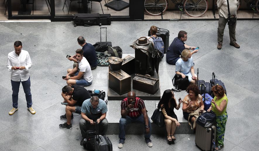 Passengers wait during rail strike at the Atocha station in Madrid, Spain, Wednesday, July 31, 2019. Spanish national rail operator Renfe has canceled hundreds of train journeys on one of the busiest travel days of the year due to a strike over staffing levels. The company said more than 700 scheduled services wouldn't operate Wednesday, a day when many people would normally head off for their summer vacation. (AP Photo/Manu Fernandez)