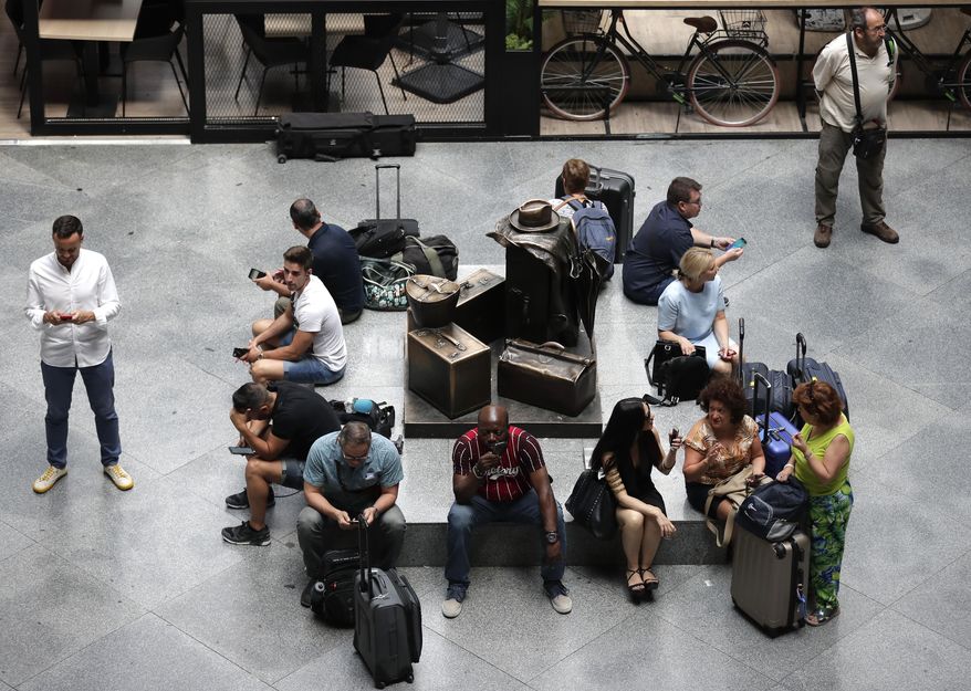 Passengers wait during rail strike at the Atocha station in Madrid, Spain, Wednesday, July 31, 2019. Spanish national rail operator Renfe has canceled hundreds of train journeys on one of the busiest travel days of the year due to a strike over staffing levels. The company said more than 700 scheduled services wouldn't operate Wednesday, a day when many people would normally head off for their summer vacation. (AP Photo/Manu Fernandez)