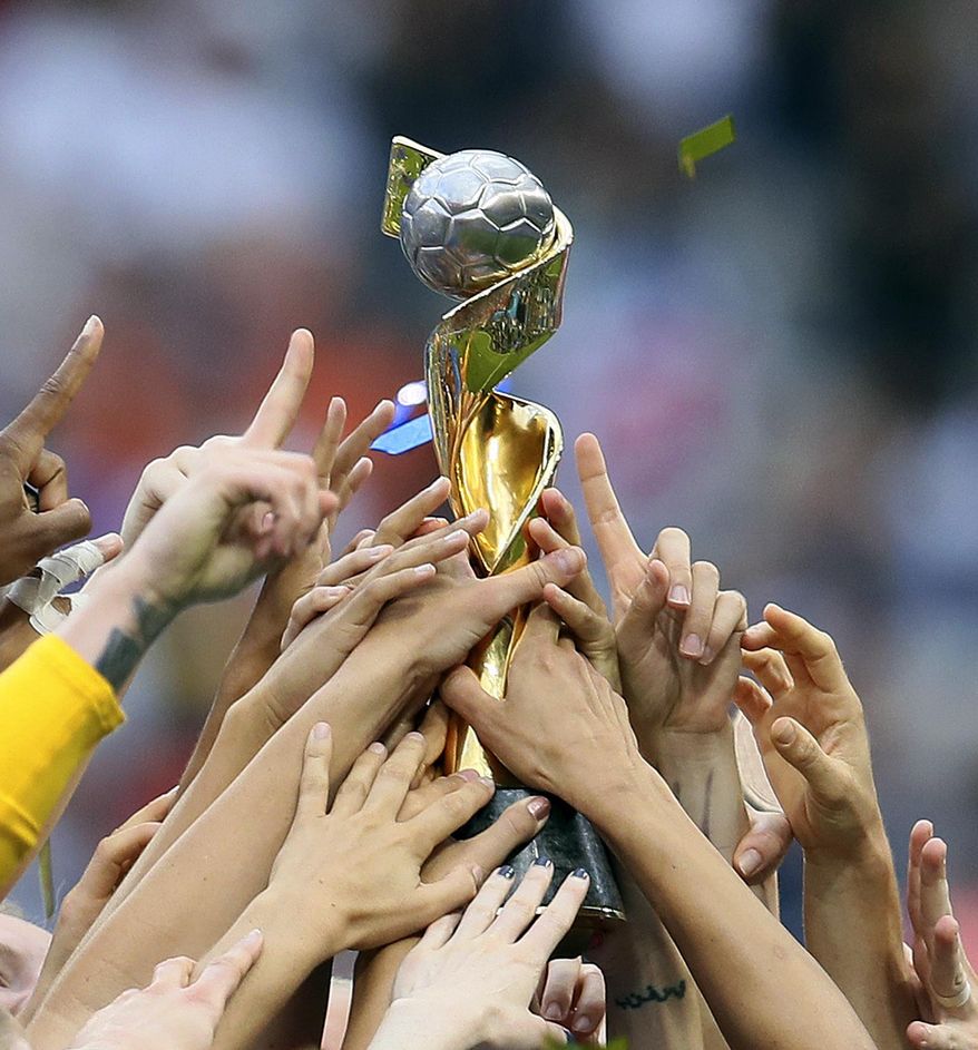 In this July 7, 2019, file photo, U.S. players hold the trophy as they celebrate their victory in the Women's World Cup soccer final in Decines, outside Lyon, France. FIFA's Council has unanimously approved expanding the Women's World Cup from 24 teams to 32 for 2023 and has reopened bidding to host the tournament but made no mention of changing prize money. FIFA said Wednesday, July 31, 2019, the decision was made remotely. (AP Photo/David Vincent, File) **FILE**