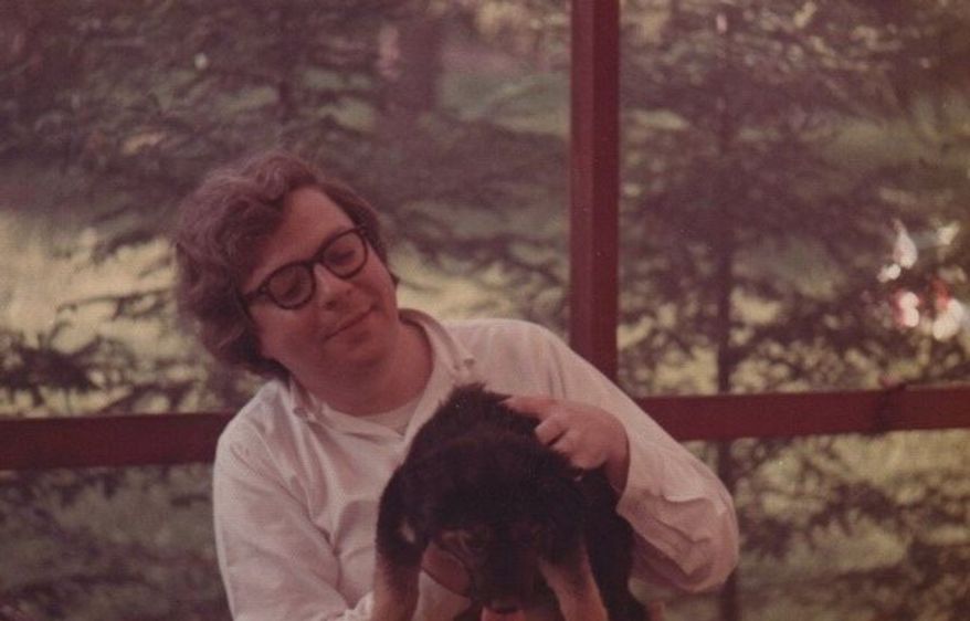 A young, smiling, shaggy-haired Bill Schulz sitting on my family&#39;s back porch in Carmel, New York. In his lap is the scruffy family dog named Lady Muttley.