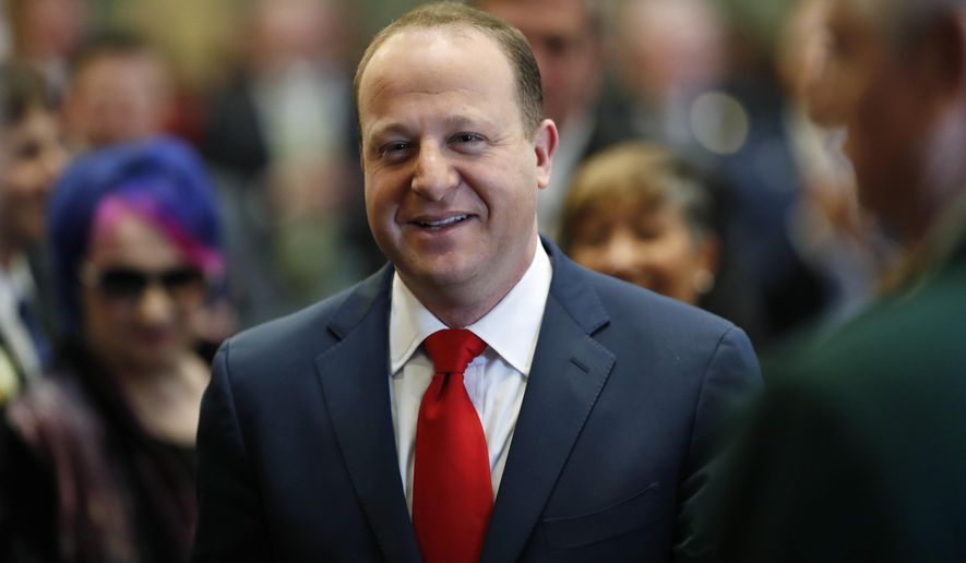 FILE - In this Jan. 10, 2019 file photo, Colorado Governor Jared Polis enters the House of Representatives chamber in Denver. Activists say they've gathered enough voter signatures to challenge a law signed by Polis that would pledge Colorado's presidential electoral votes to the winner of the national popular vote. (AP Photo/David Zalubowski, File)