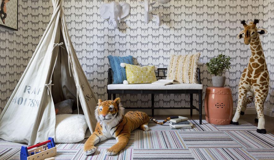 This undated photo provided by Hermosa Beach, Calif., based designer Kate Lester shows a safari-themed playroom designed by Lester near Los Angeles. A soothing palette and unexpected artsy elements like the animal head wall art and Marley + Malek Kids wallpaper assure the space will grow with the kids. Lester says she and her team use removable floor tiles like these on almost all their projects. They're rugged and washable, and if one gets stained it can be changed out. (Amy Bartlam/Kate Lester via AP)