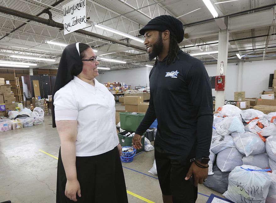 In this June 27, 2019, file photo, Sister Marie Jose De La Rosa, from New Jersey, chats with Washington Redskins cornerback Josh Norman at the Humanitarian Respite Center in McAllen, Texas. Most NFL players don’t have the kind of offseason adventures of Josh Norman, who flew with the Blue Angels, visited and donated to an immigrant detention center in Texas and jumped over a bull while running with the bulls in Pamplona, Spain. (Delcia Lopez/The Monitor via AP, File) **FILE**