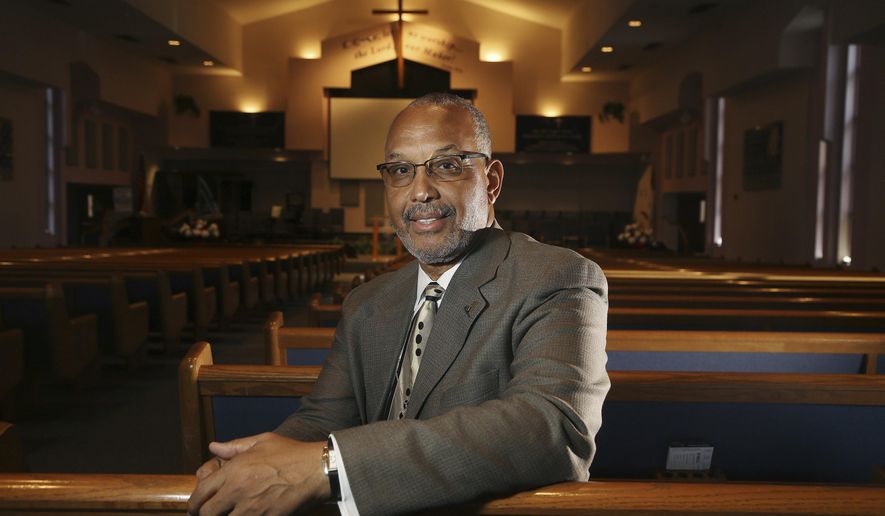 In this Tuesday, July 30, 2019 photo,  Civil Rights leader Rev. Dr. Warren H. Stewart Sr. sits in the sanctuary of his church, the Institutional Baptist Church, in Phoenix. Phoenix’s past segregation has been in focus after this summer’s national outrage over a videotaped encounter of police pointing guns and cursing at a black family. “That has long been a reality for African Americans, to not be treated fairly by the police,” said Stewart. “Segregation has been outlawed, but the remnants of systemic racism and discrimination remain.”  (AP Photo/Ross D. Franklin)