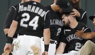 Colorado Rockies third baseman Nolan Arenado, left, consoles center fielder David Dahl, who suffered and injury to his right leg while catching a fly ball hit by San Francisco Giants&#39; Scooter Gennett during the sixth inning of a baseball game Friday, Aug. 2, 2019, in Denver. (AP Photo/David Zalubowski)