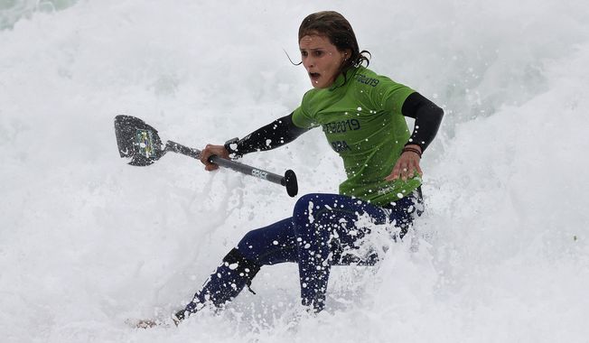 Brazil&#x27;s Lena Guimaraes rides the surf to win the gold medal in the women&#x27;s SUP race final during the Pan American Games on Punta Rocas beach in Lima Peru, Friday, Aug.2, 2019. (AP Photo/Silvia Izquierdo)