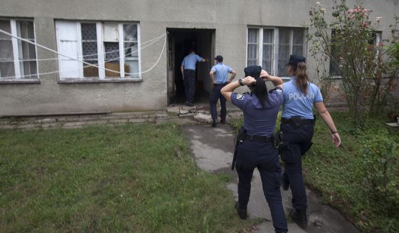 Police enter the house where a suspect killed six people, including a ten-year-old child, before committing suicide, in Zagreb, Croatia, Friday, Aug. 2, 2019. Croatian police identified the killings Friday as domestic violence. (AP Photo/Nikola Solic)