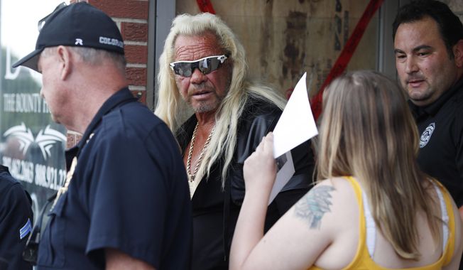 Duane &amp;quot;Dog the Bounty Hunter&amp;quot; Chapman, back, charts with his daughter, Bonnie Jo, outside his storefront that was burglarized before a news conference Friday, Aug. 2, 2019, in Edgewater, Colo. Police in Colorado said Friday they are investigating a reported burglary of a business owned by &amp;quot;Dog the Bounty Hunter&amp;quot; reality TV star Duane &amp;quot;Dog&amp;quot; Chapman. (AP Photo/David Zalubowski)