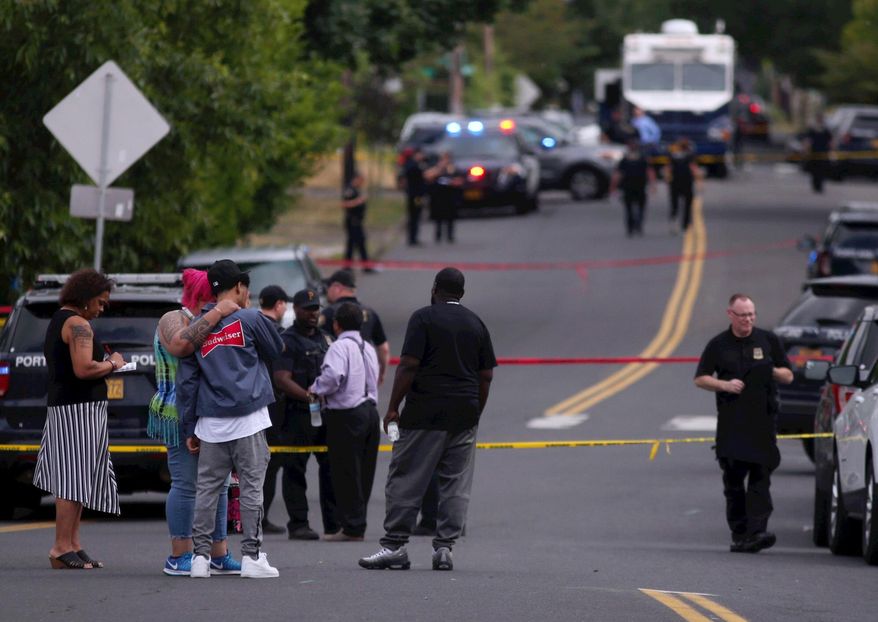 Portland police respond to a fatal shooting in Northeast Portland, Ore., on Friday, Aug. 2, 2019. The Portland Police Bureau says officers responding to a shooting report just after 2 p.m. Friday found multiple victims injured. (Beth Nakamura/The Oregonian via AP)